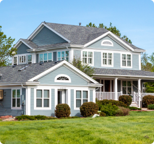 Two-story blue house with a front porch and green lawn